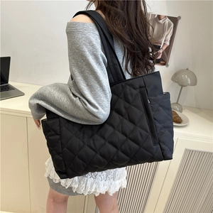 Black quilted tote bag for women featuring a spacious interior and casual puffer style