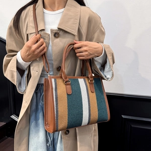 Minimalist striped canvas tote bag with brown leather handles for stylish commuting