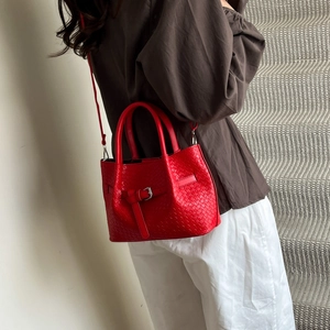 Red woven bucket bag with silver buckle and cross-weave texture for daily commute
