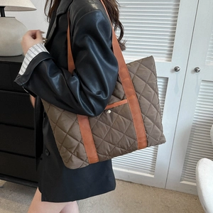 Brown quilted tote bag with large capacity and contrasting orange shoulder straps for daily use