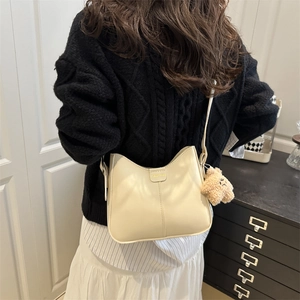 Chic beige shoulder bag with gold Fashion lettering and a cute plush bear charm