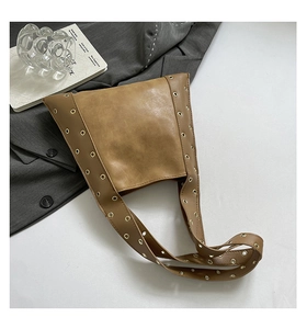 Détail du sac cabas marron rétro avec œillets métalliques et texture en similicuir lisse