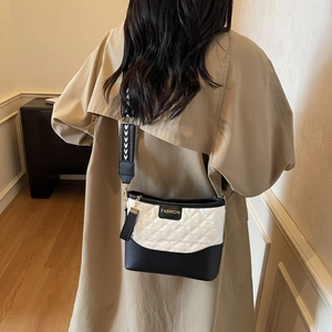 Chic quilted black and white crossbody bag with geometric strap and gold hardware