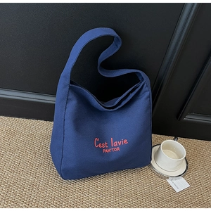 Détail du sac fourre-tout en toile bleu marine avec broderie rouge C'est la vie au café