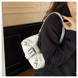 Detail of white patent leather shoulder bag featuring pleated texture and silver buckles