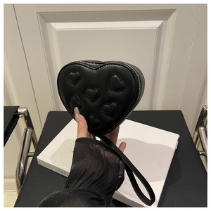 Dettaglio della borsa nera a forma di cuore con motivi trapuntati e finitura raffinata