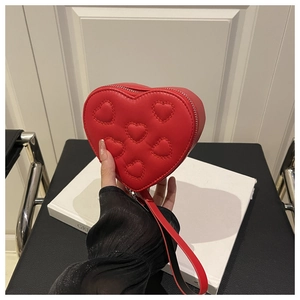 Dettaglio della borsa rossa a forma di cuore con mini cuori a rilievo e zip argentata