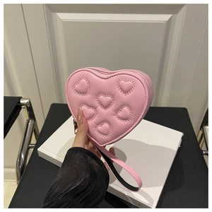 Dettaglio mini borsa rosa a forma di cuore con motivi 3D in rilievo e pelle opaca liscia