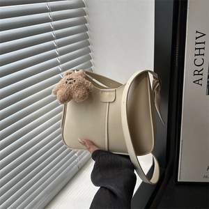 Chic cream hobo shoulder bag with fashion embossing and brown plush bear charm
