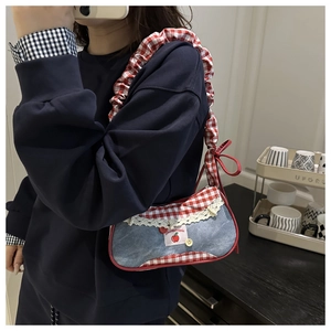 Détail du sac cabas en denim avec bordure en dentelle blanche et motifs de pommes