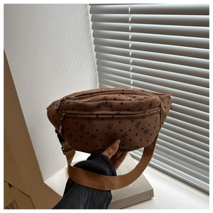 Close-up of brown corduroy chest bag with floral patterns and dual zipper design