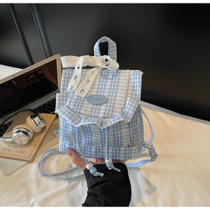 Detailed view of the lace bow and fashion tag on this blue plaid mini ruffle backpack