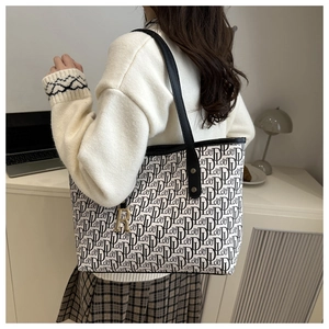 Grand sac cabas chic avec imprimés lettres et pendentif doré dans un décor de style de vie