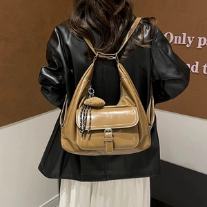 Caramel brown hobo bag with contrast stitching and fluffy charm on a model
