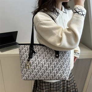 Sac fourre-tout monogramme noir et blanc avec pendentif R doré et fines bandoulières