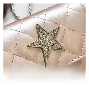 Dettaglio borsa trapuntata oro rosa con decorazione a stella impreziosita da strass