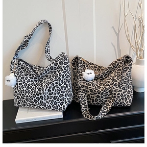 Détail de cabas en toile à motif léopard avec un pendentif peluche monstre mignon