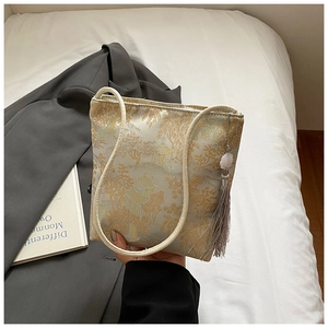 Detail of jacquard silk shoulder bag with landscape patterns and tassel ornament