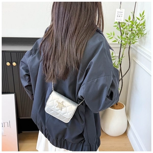 Dettaglio della mini borsa trapuntata argento con stella indossata da una modella
