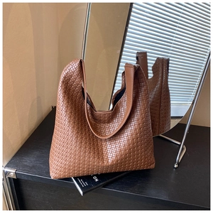 Close-up of the intricate brown leather weave pattern on the large hobo shoulder bag