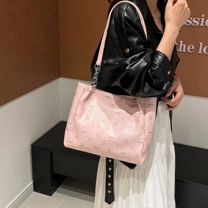 Pink printed tote bag with bunny patterns and silver chain strap shown on a model