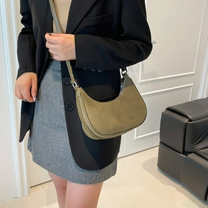 Olive green suede crescent moon crossbody bag with studs and silver metal zipper