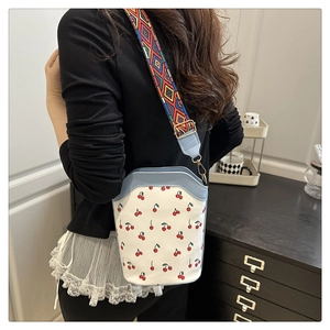Detail der Kirsch-Beuteltasche mit Ethno-Webgurt und blauem Lederbesatz am Rand