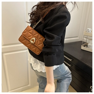 Détail du sac bandoulière en cuir matelassé caramel avec chaîne dorée et fermoir