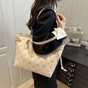 Retro cream tote bag with rabbit print and diamond quilting shown on a model's shoulder