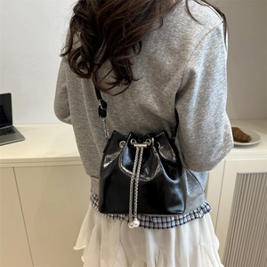 Chic black oil wax leather bucket bag with chain pearl drawstring and adjustable strap