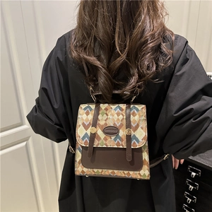 Retro multi-color plaid backpack with brown leather flap and golden hardware accents