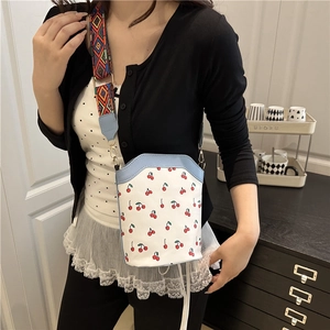 Minimalistische Canvas-Beuteltasche mit rotem Kirschprint und buntem Web-Schultergurt