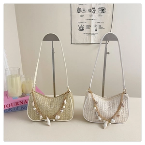 Detail of woven straw shoulder bags with ocean charms including shells and pearls