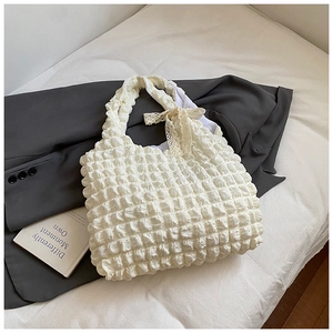 Detail of white puff texture fabric tote bag with elegant lace bow on handle