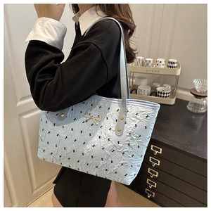 Sac fourre-tout matelassé bleu avec motifs de nœuds noirs et boucle dorée chic