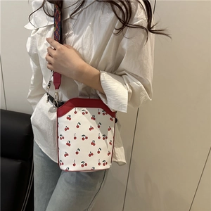 Damen-Eimertasche mit Kirschdruck, rotem Rand und farbigem gewebtem Schultergurt