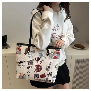 Détail du cabas blanc avec illustrations de graffiti colorées et anses en cuir noir