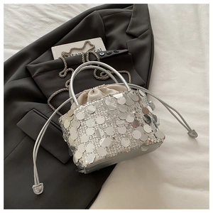 Detail of silver sequin bucket bag with drawstring closure and metallic chain