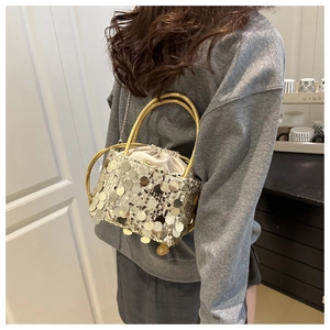 Close-up of silver sequin bucket bag with drawstring closure and metal chain strap