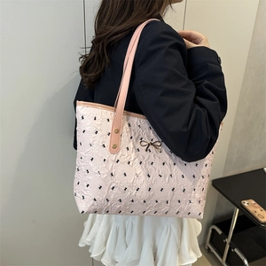 Grand sac cabas rose gaufré avec motifs de nœuds noirs et charm doré élégant