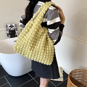 Bright yellow puff floral tote bag with textured bubble fabric shown on shoulder