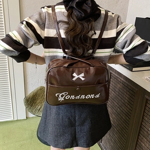 Brown glossy PU leather tote bag with white bow and embroidery shown in use