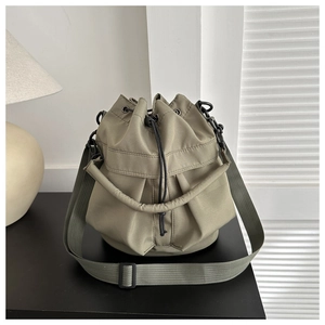 Detail view of khaki nylon bucket bag with drawstring closure and adjustable strap