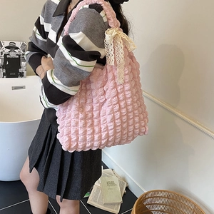 Pink puff textured tote bag with lace bow detail shown in a stylish indoor setting
