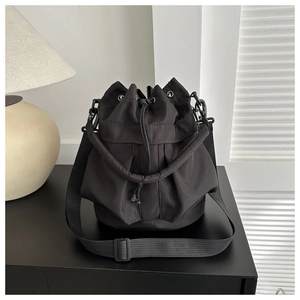 Detail of black drawstring bucket bag with durable nylon fabric and metal eyelets