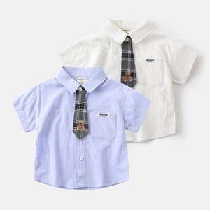 Detail of baby boy shirts showing cotton texture, pocket tags and bear ties in white and lilac