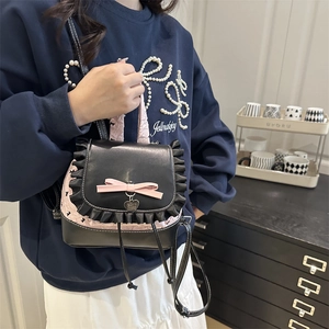 Sweet pink and black lace mini backpack with bow and heart pendant on a model