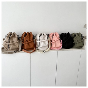 Grote nylon bucket bags met trekkoord in diverse kleuren op een witte tafel