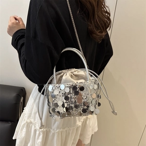 Chic silver sequin drawstring bucket bag with a delicate metal chain shoulder strap
