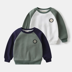 Macro detail of boys' waffle knit raglan sweatshirts with stitched letter patches